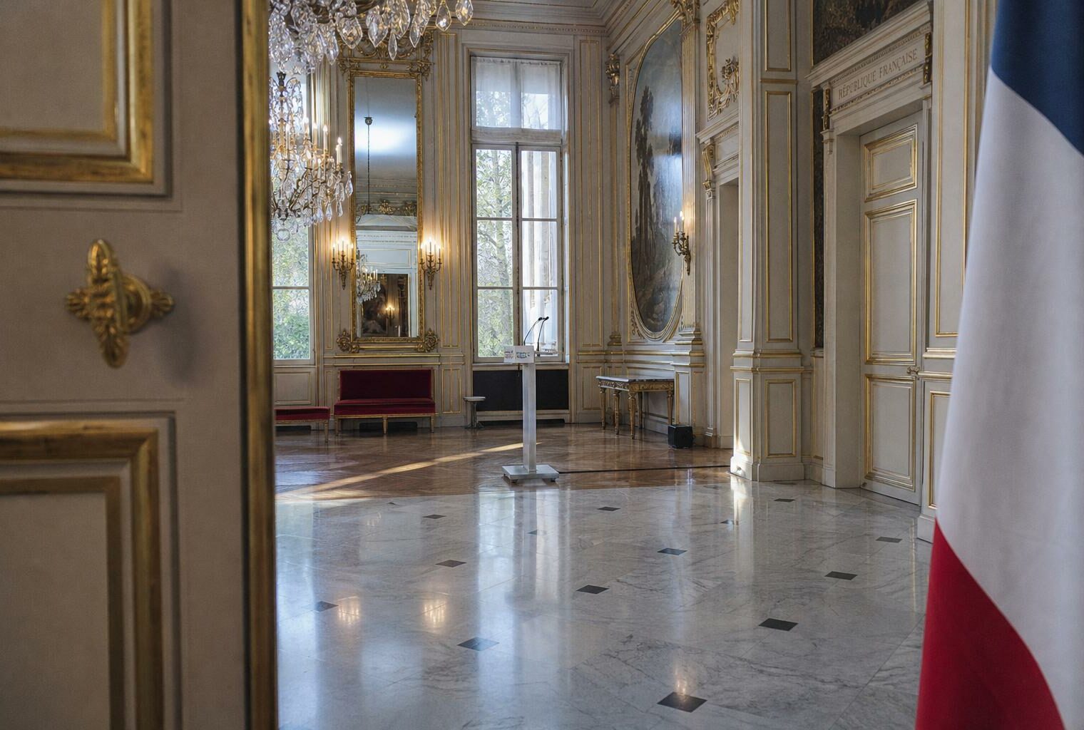 Salle de réception à l’Élysée avec pupitre vide, drapeau tricolore partiel et ambiance institutionnelle autour du débat sur le Code noir.