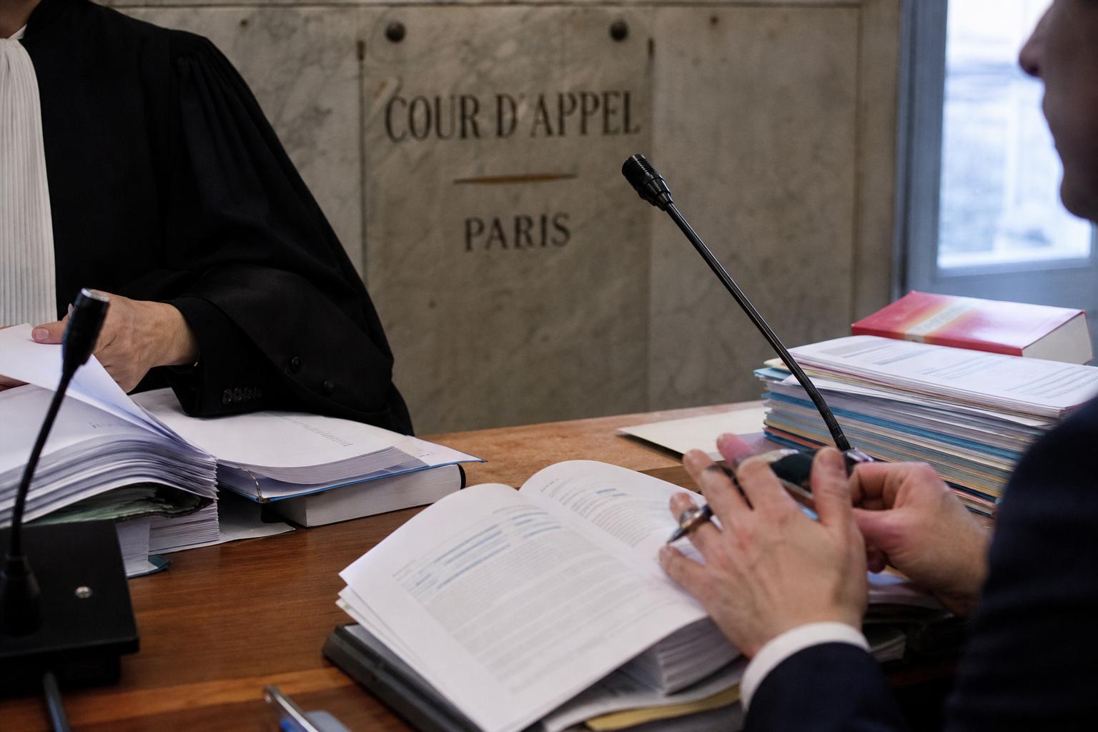 Photo de presse dans un palais de justice parisien avec dossiers judiciaires et robe de magistrat pour illustrer l’affaire Sarkozy Libye