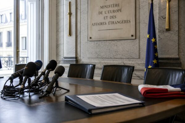 Salle de briefing diplomatique à Paris avec micros, drapeau français partiel et ambiance institutionnelle après une tension UE-Israël