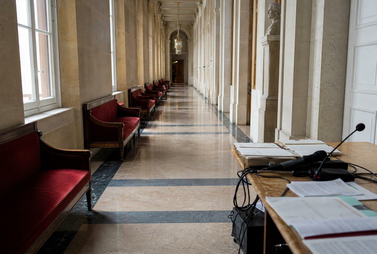 Couloir vide du Palais Bourbon avec marbre clair, lumière naturelle et ambiance institutionnelle calme.
