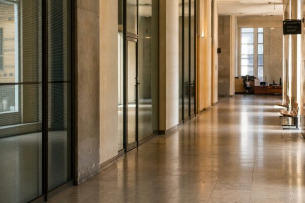 Couloir lumineux d’un tribunal parisien, vide et sobre, avec lignes architecturales et ambiance judiciaire contemporaine.
