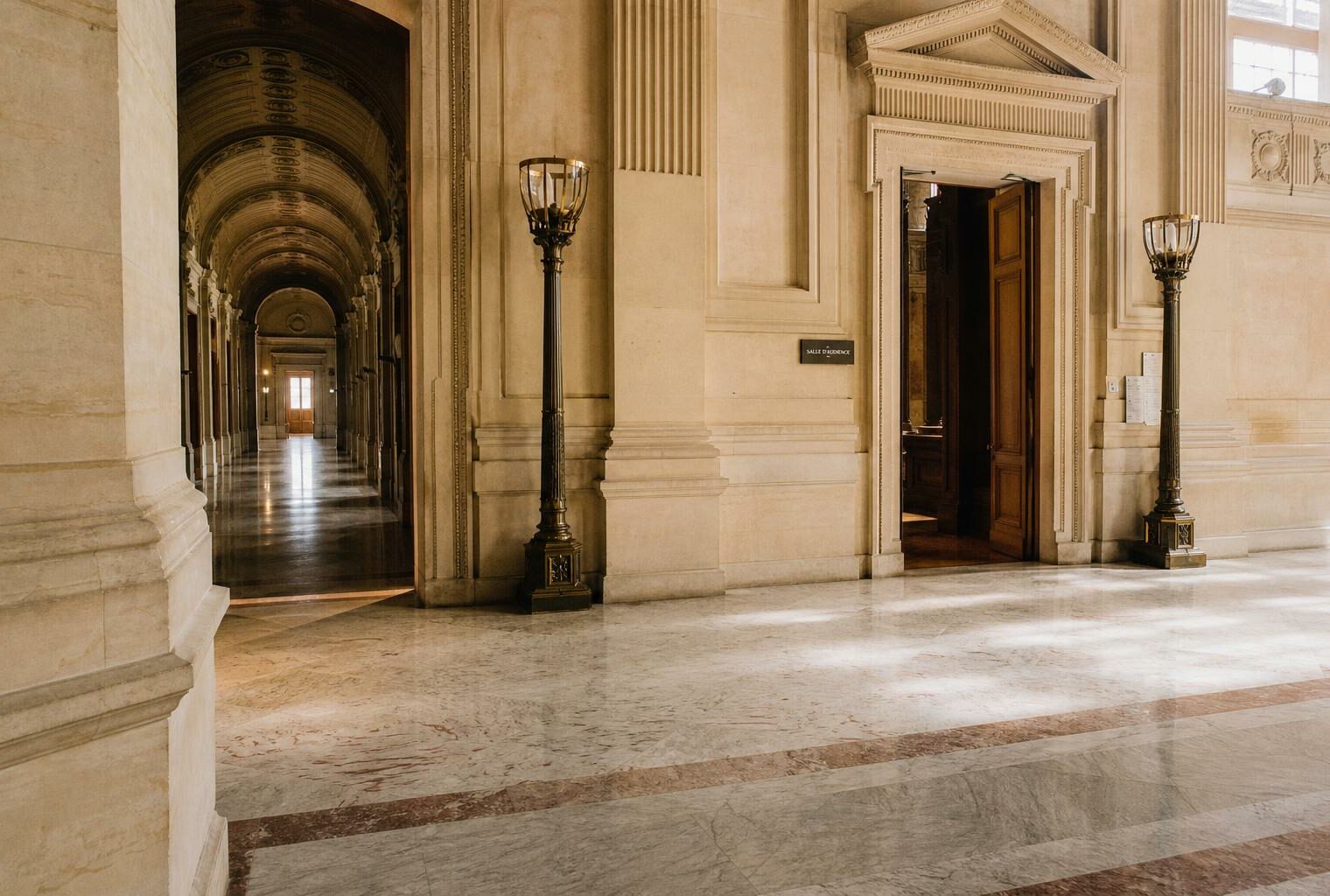 Hall vide de la cour d’appel de Paris, lumière naturelle claire, ambiance judiciaire sobre et institutionnelle.