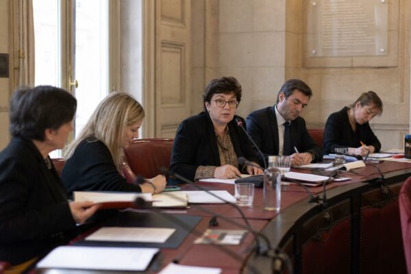 Réunion institutionnelle en France autour du débat sur la panthéonisation de Samuel Paty, avec cinq personnes et micros de commission.