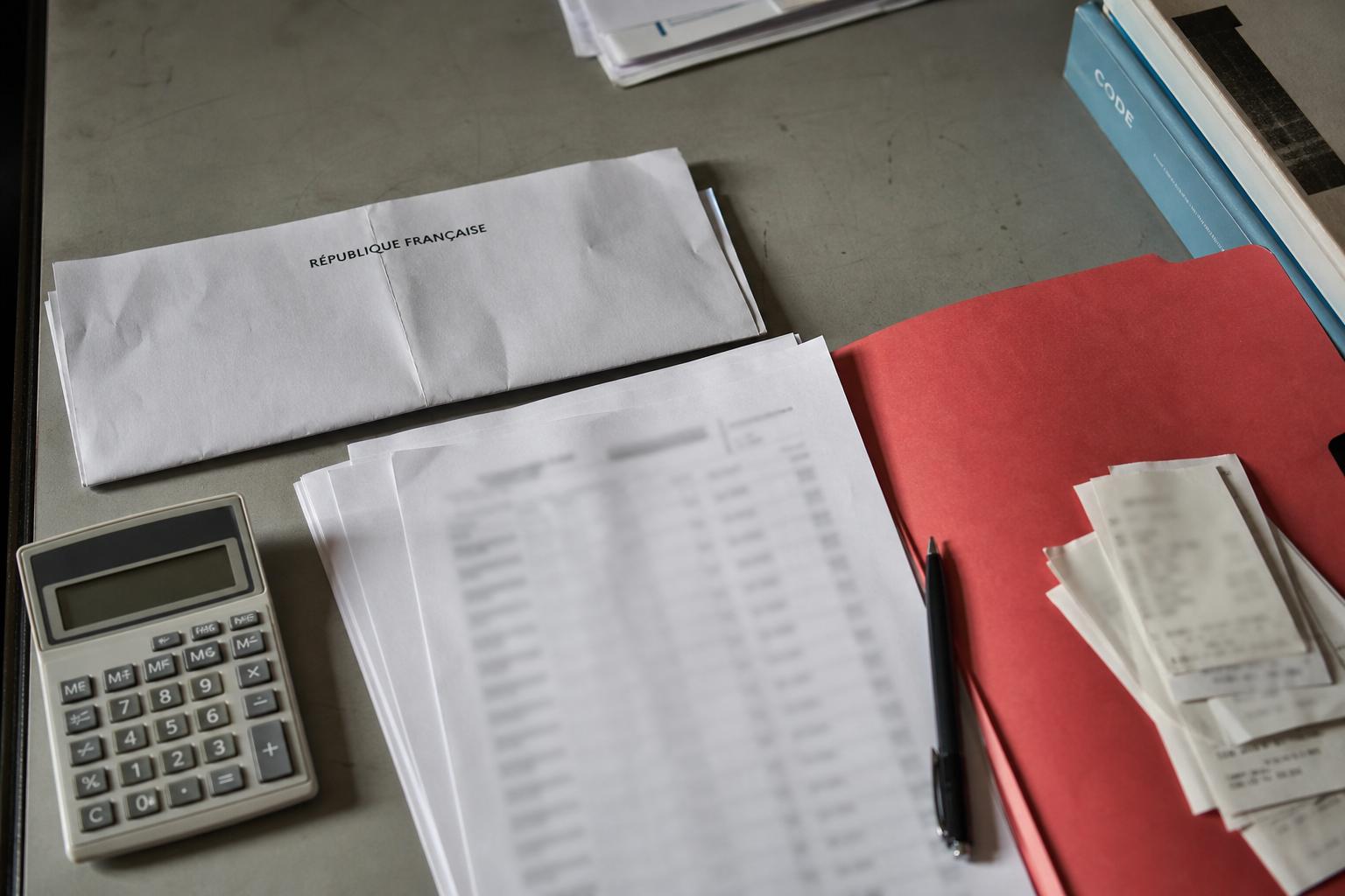 Contrôle des frais de mandat des députés sur un bureau administratif français avec documents officiels, calculatrice et dossiers