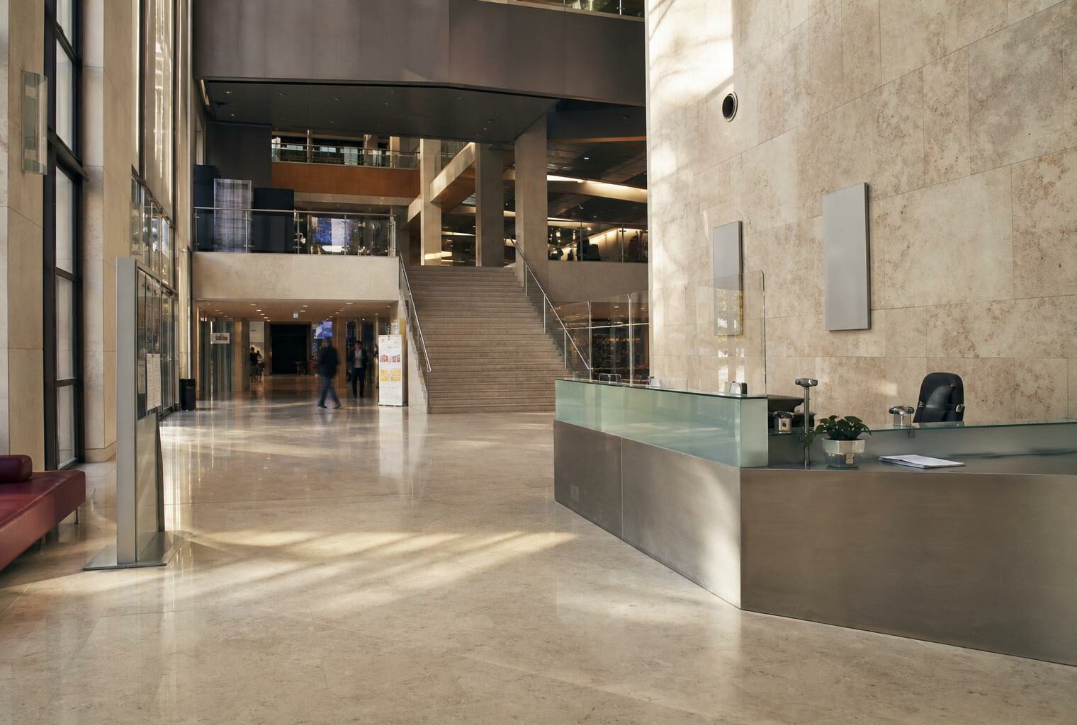 Hall d’un siège de média parisien, vu en légère oblique, avec lumière naturelle et ambiance institutionnelle.