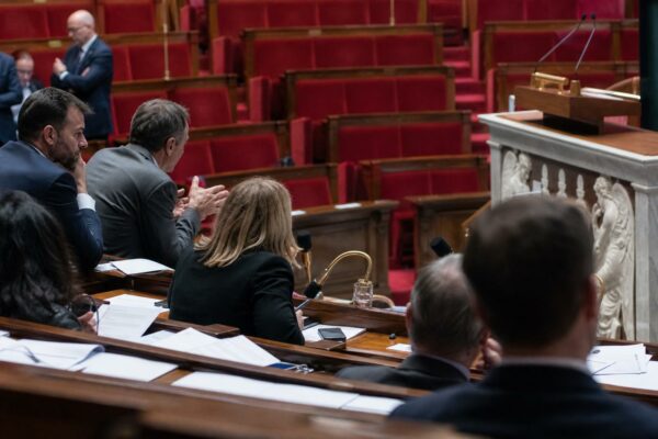 Vue oblique de l’hémicycle de l’Assemblée nationale avec sièges rouges et pupitre, pour illustrer le débat sur la loi d’urgence agricole.