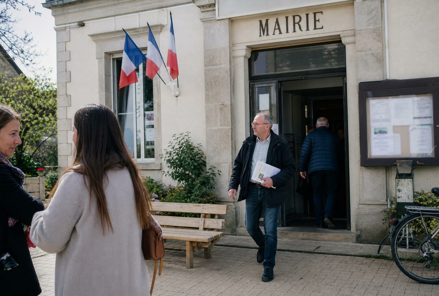 Des habitants anonymes devant une mairie de quartier, dans une scène de vie citoyenne en lumière naturelle.