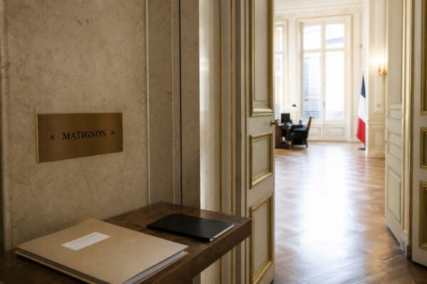 Couloir lumineux de Matignon avec dossier de briefing, dans une atmosphère institutionnelle calme et réaliste.