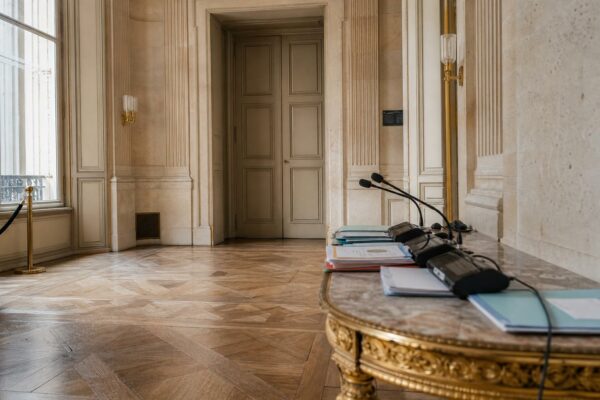 Couloir lumineux de Matignon avec dossiers et micros après une réunion sur la criminalité organisée
