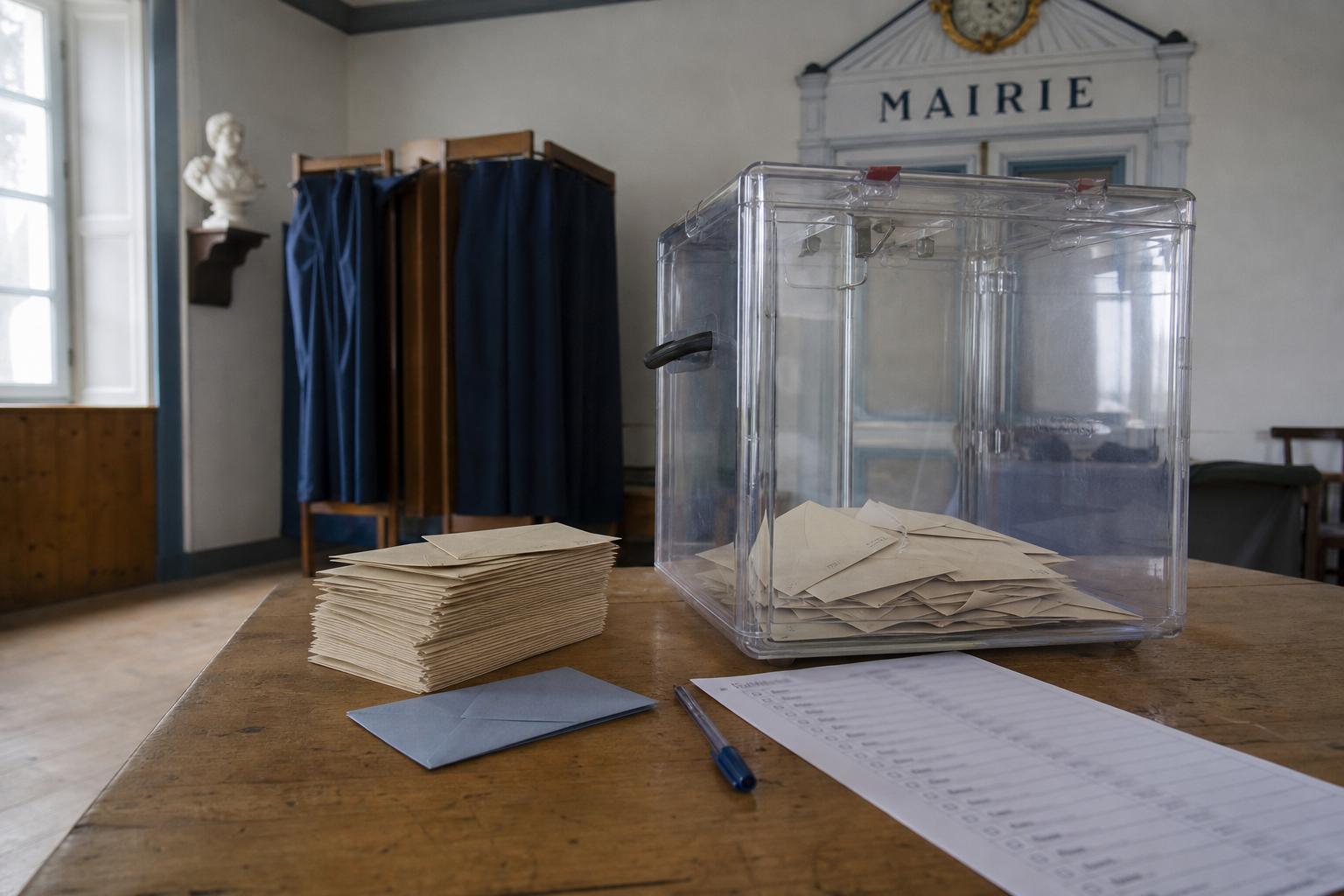 Urne transparente et bulletins de vote dans une mairie de l’île de Molène pour une élection municipale partielle.
