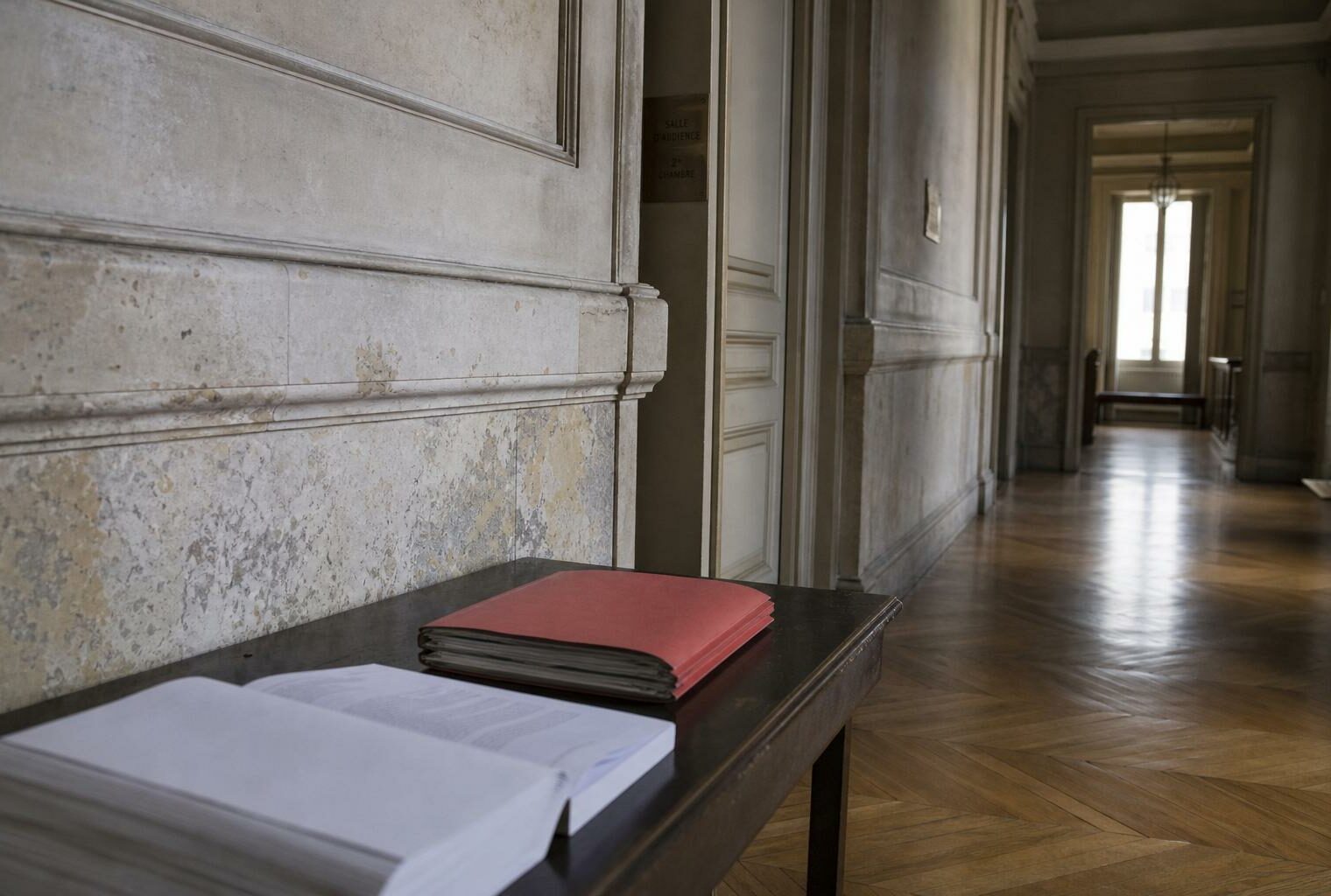 Couloir institutionnel parisien avec dossier rouge et code juridique, illustrant le débat sur l’état d’urgence contre le narcotrafic.