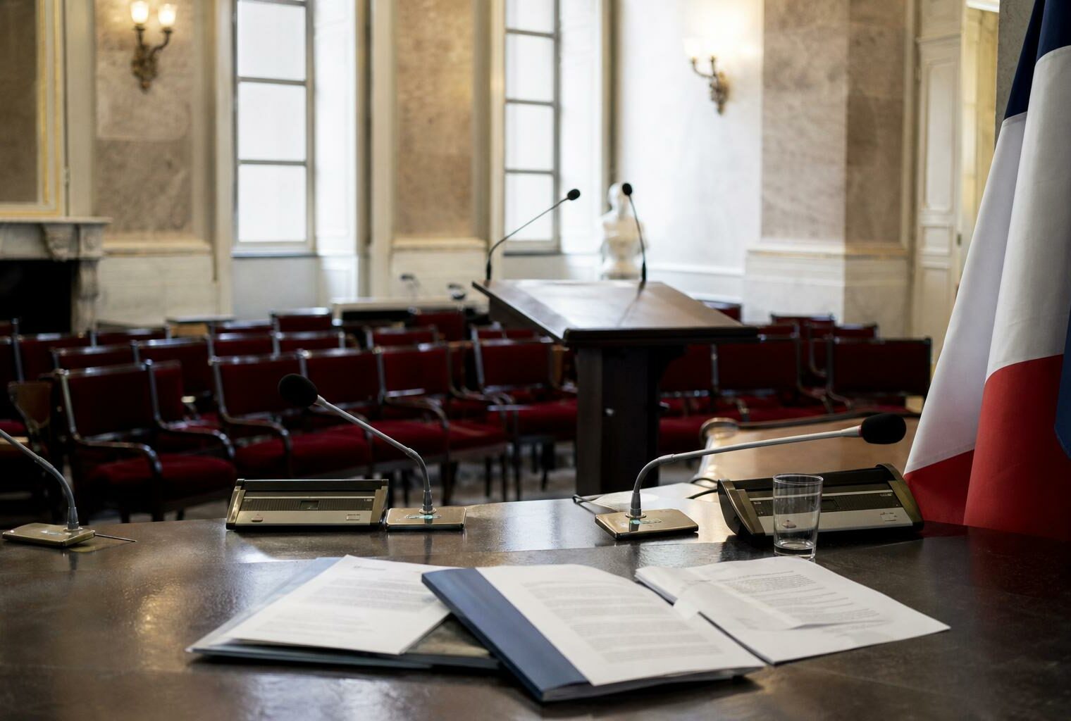 Salle de presse municipale vide avec micros et pupitre, illustrant le débat autour des concerts de Patrick Bruel.