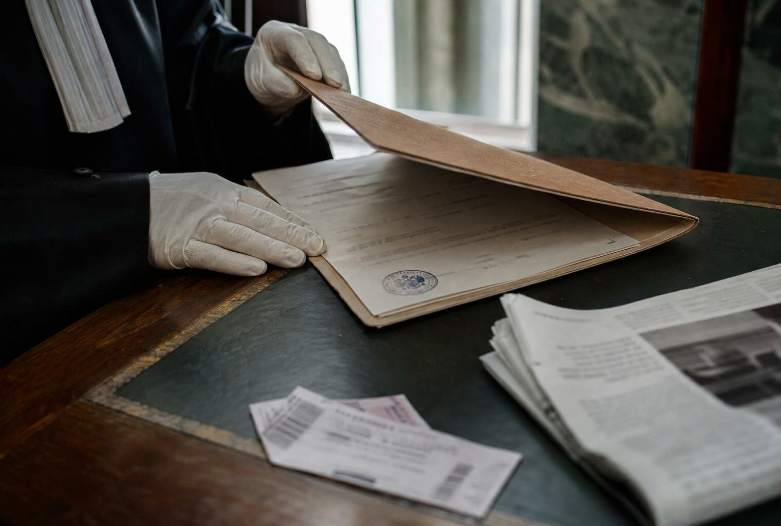 Scène de justice dans un palais de justice français avec dossier judiciaire et documents flous, illustrant le débat sur la présomption d’innocence.