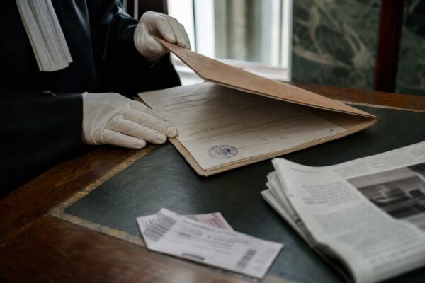 Scène de justice dans un palais de justice français avec dossier judiciaire et documents flous, illustrant le débat sur la présomption d’innocence.