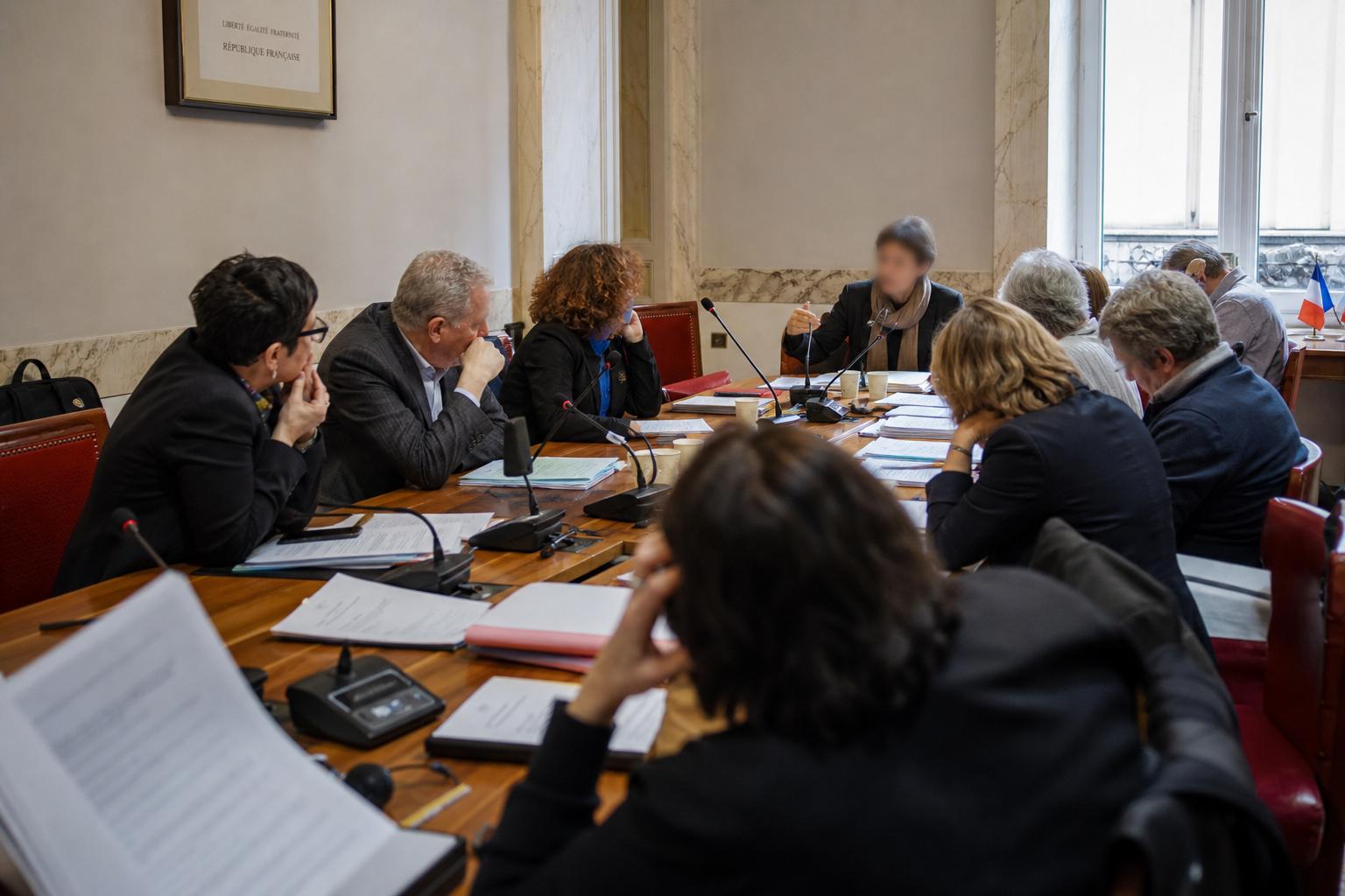 Réunion politique de presse en France autour d’un programme commun à gauche, avec micros et dossiers sur une table.