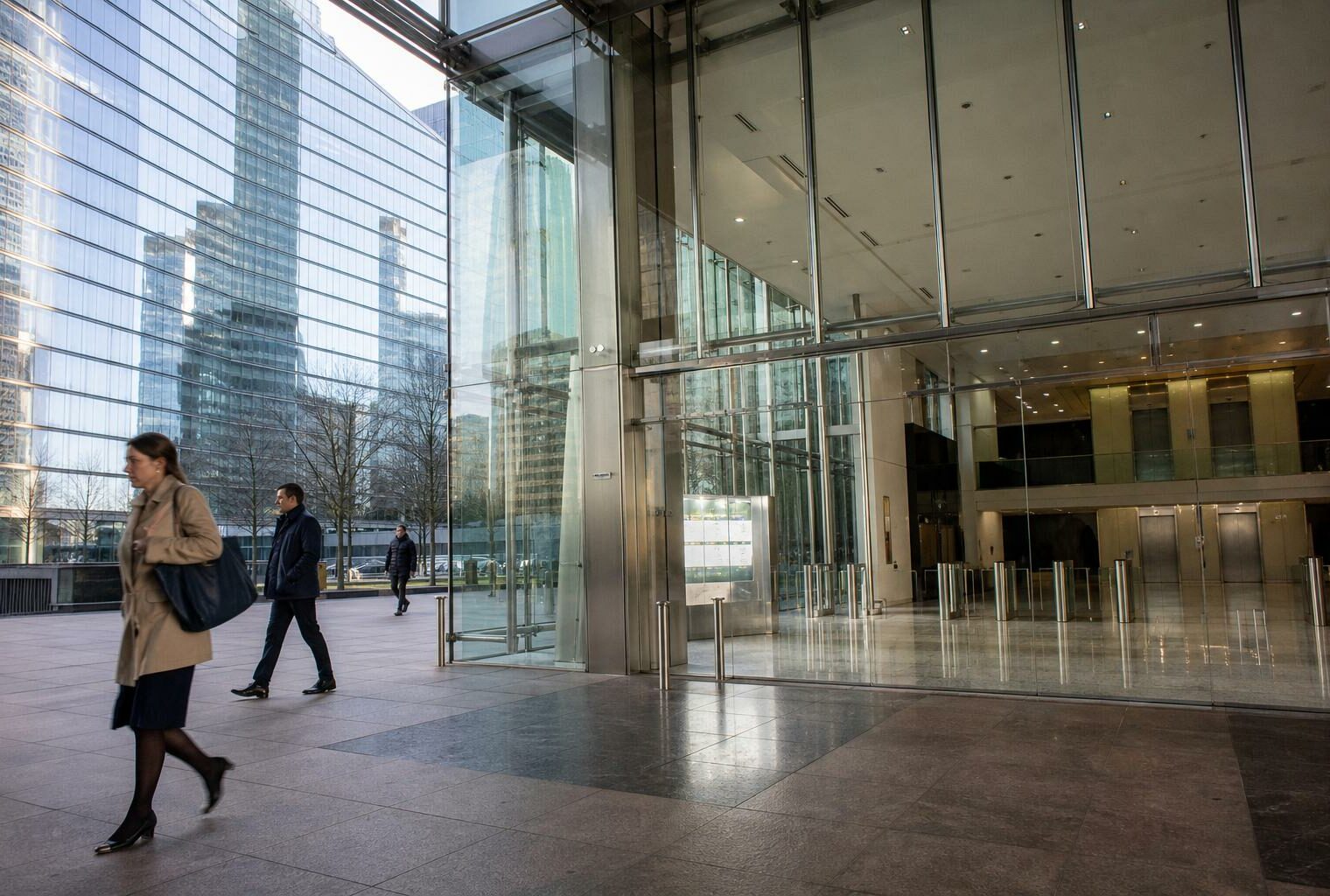 Hall d’immeuble de bureaux à La Défense avec façade vitrée, lumière naturelle et ambiance institutionnelle calme.