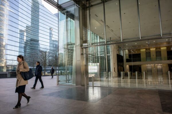 Hall d’immeuble de bureaux à La Défense avec façade vitrée, lumière naturelle et ambiance institutionnelle calme.