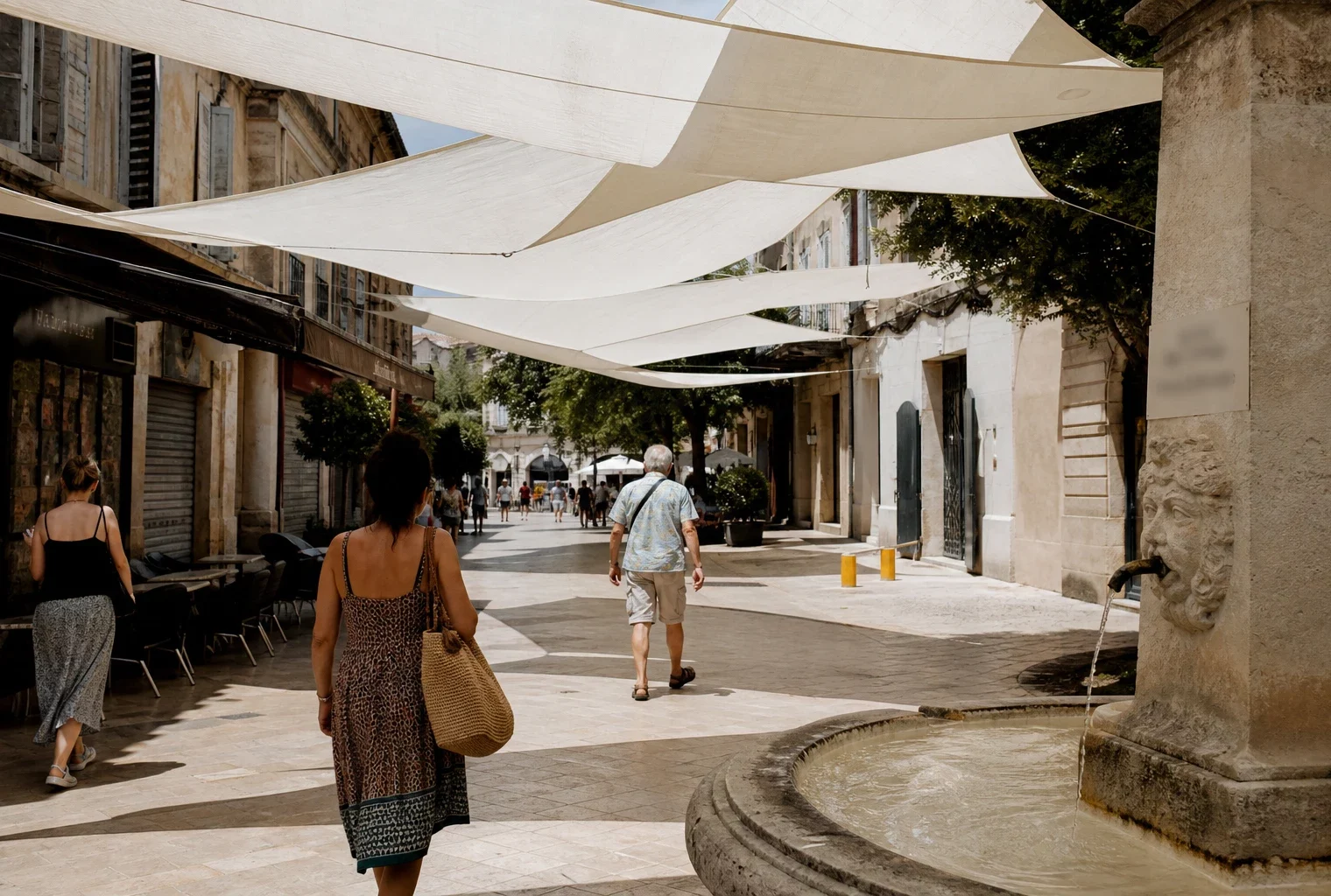 Rue française en été avec toiles d’ombrage, passants anonymes et façades ensoleillées pendant une vague de chaleur.