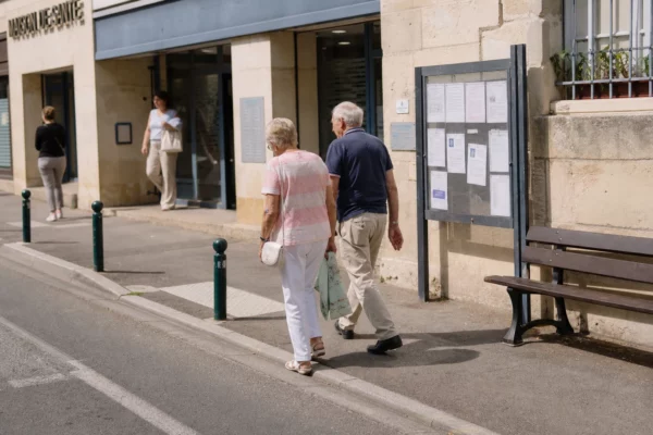 Scène de rue dans une ville française, avec habitants anonymes devant un équipement de santé local.