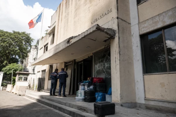 Façade endommagée de l’ambassade de France à Caracas avec secouristes et matériel d’urgence devant l’entrée.