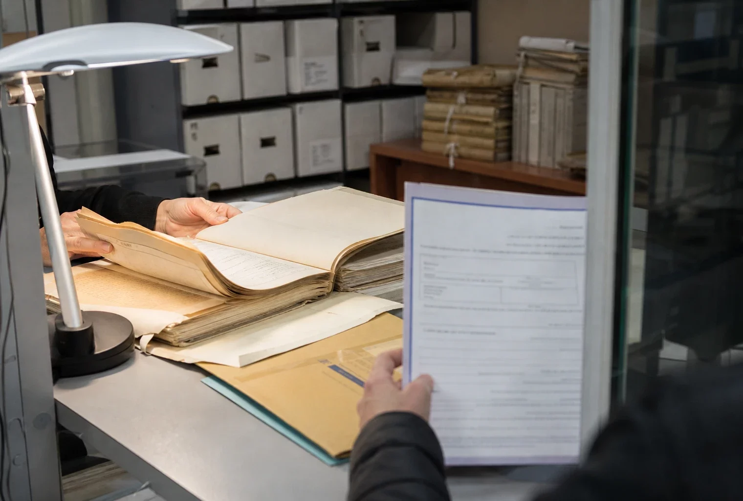 Main anonyme feuilletant un dossier d’archives dans un bureau administratif français, avec lumière claire et documents flous.