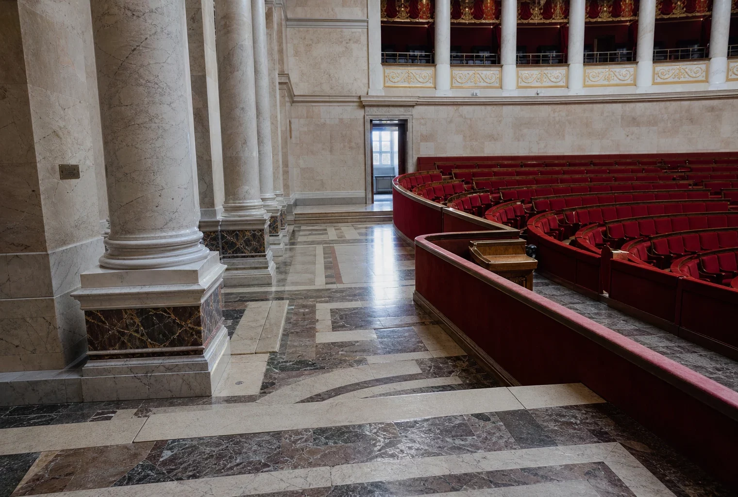 Salle des Quatre-Colonnes vide à l’Assemblée nationale, vue oblique avec marbre clair et sièges rouges