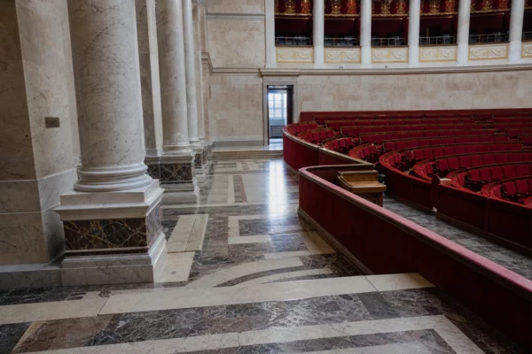 Salle des Quatre-Colonnes vide à l’Assemblée nationale, vue oblique avec marbre clair et sièges rouges
