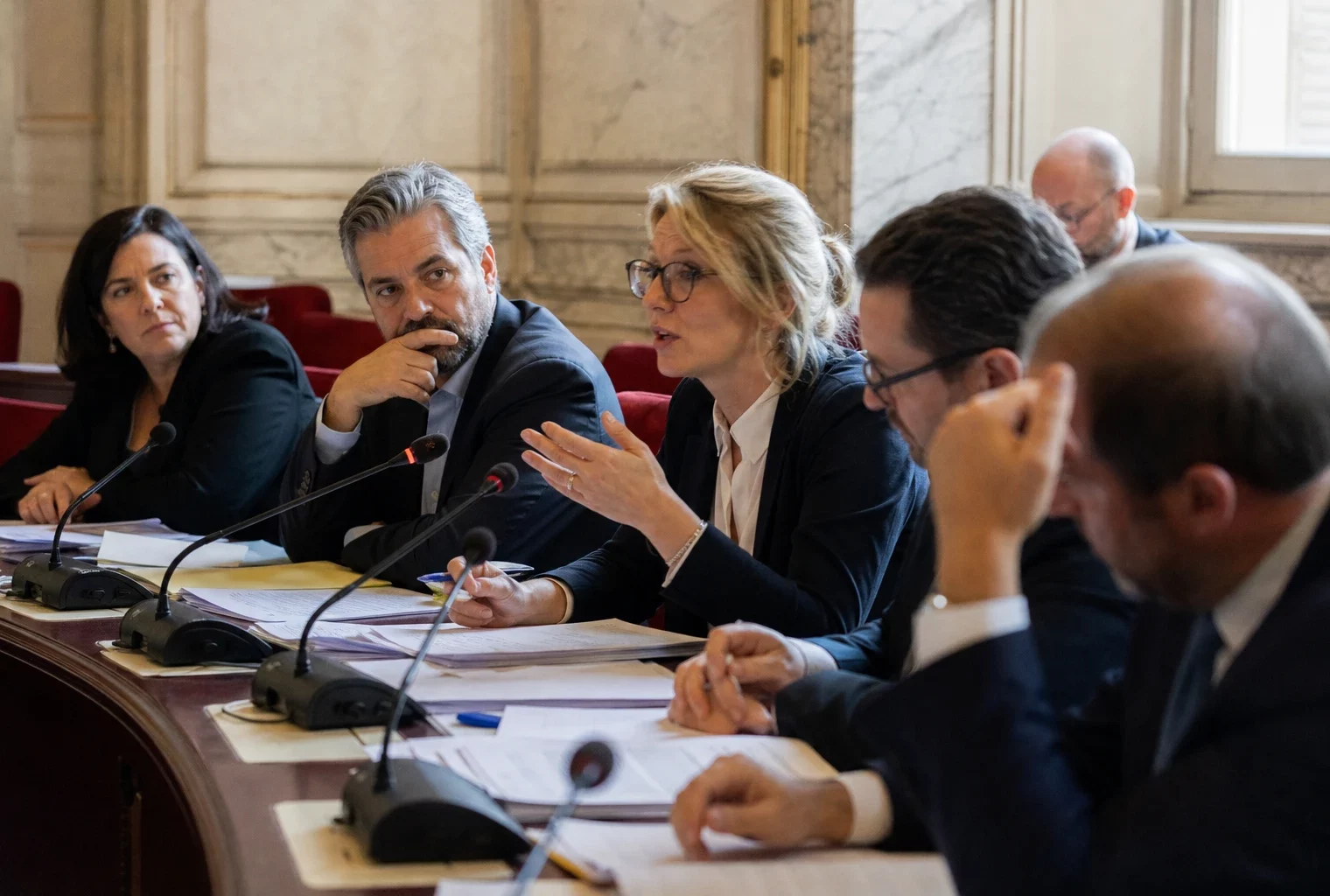 Débat en commission à l’Assemblée nationale sur la nationalisation d’ArcelorMittal, avec députés et micros en salle éclairée.