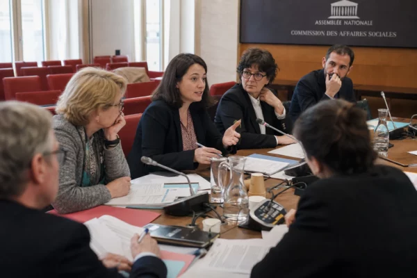 Réunion à l’Assemblée nationale sur la protection des enfants, avec députés et acteurs associatifs autour d’une table.