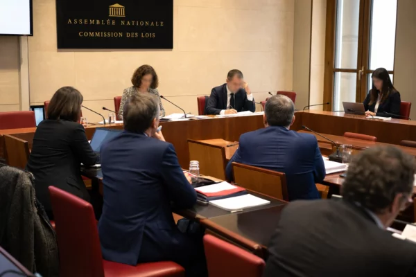 Réunion de commission à l’Assemblée nationale avec micros, dossiers ouverts et députés anonymes