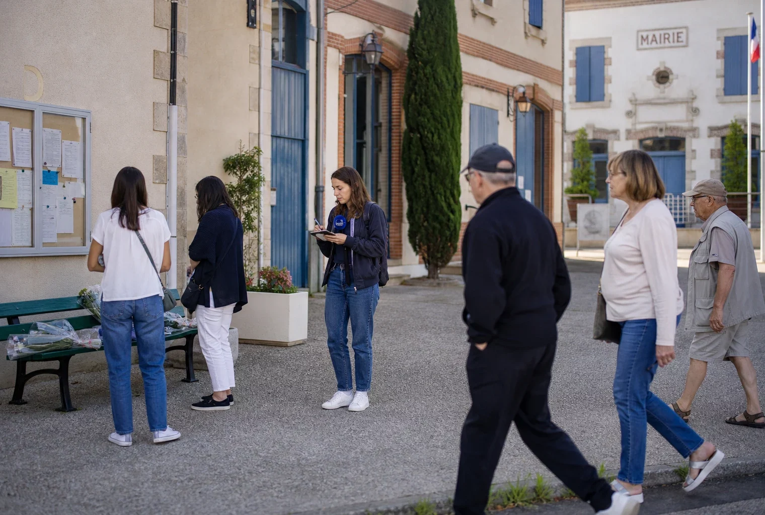 Place de mairie en province avec habitants anonymes, reporter local et fleurs discrètes dans une ambiance calme et lumineuse.