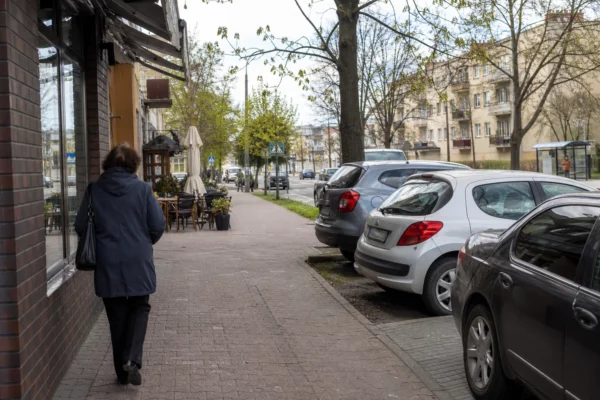 Rue calme à Biała Podlaska avec passants anonymes et voitures civiles, dans une ville polonaise proche de la frontière.