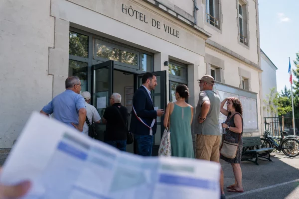 Des habitants attendent devant une mairie française pendant la canicule, dans une scène de service public au soleil.