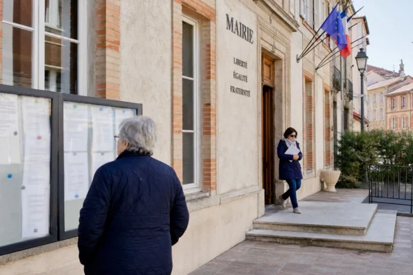 Des habitants devant la mairie de Castres dans une scène de vie citoyenne calme et réaliste.