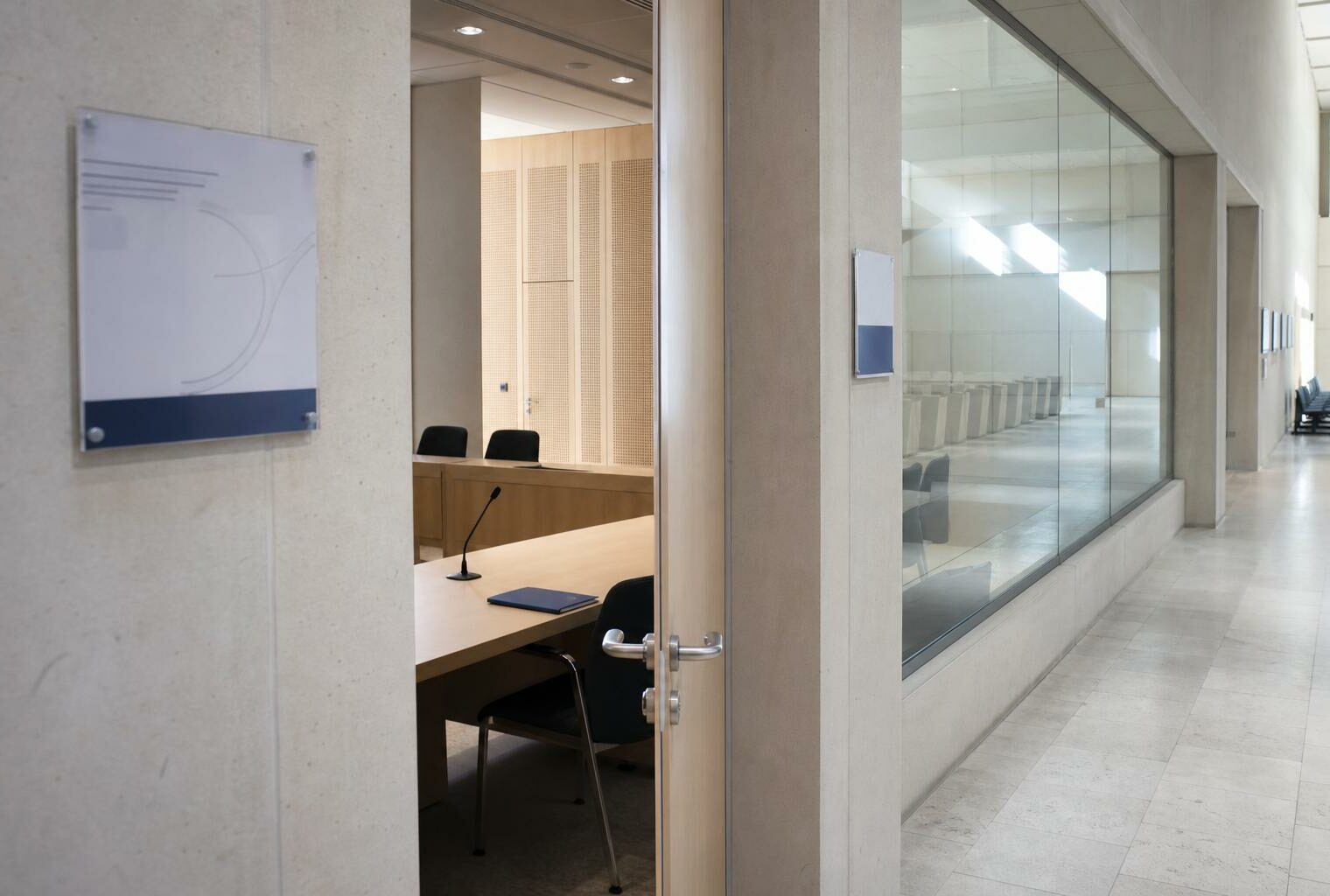 Couloir clair d’un régulateur français avec porte ouverte sur une salle d’audition vide