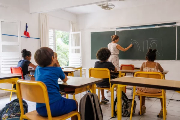 Classe française lumineuse avec élèves anonymes, tableau abstrait et ambiance de fraîcheur en plein été à Toulouse