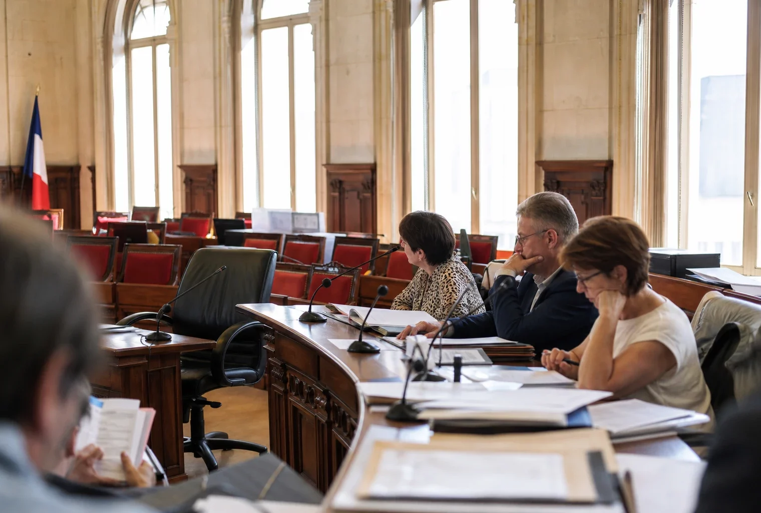 Salle municipale vide avec micros et dossiers flous, image de reportage sur la grève SNCF
