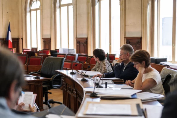 Salle municipale vide avec micros et dossiers flous, image de reportage sur la grève SNCF