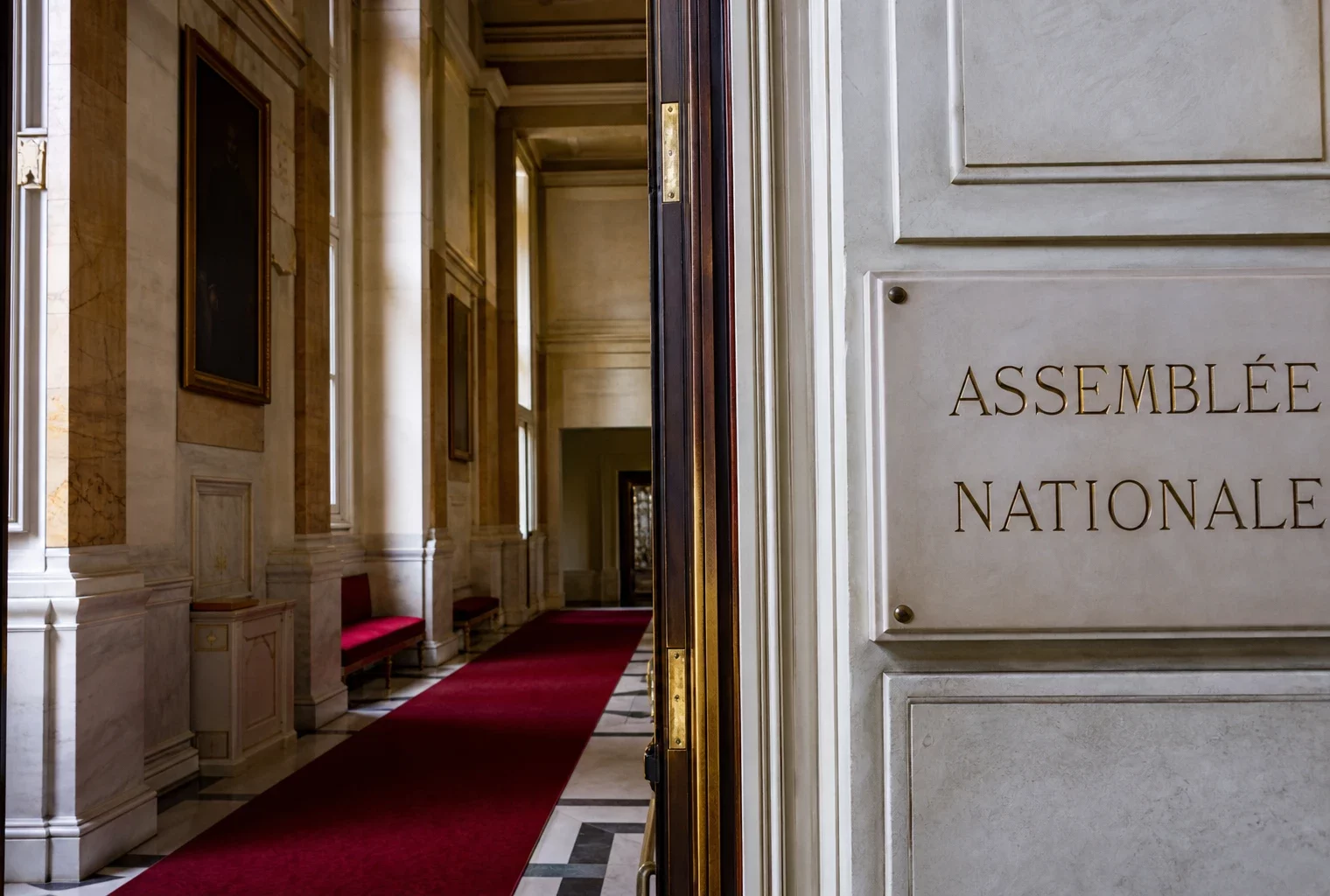 Couloir lumineux de l’Assemblée nationale, vue oblique, marbre blanc et ambiance institutionnelle vide.