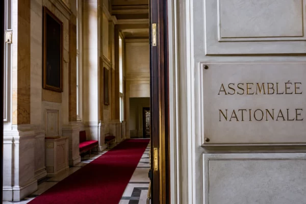 Couloir lumineux de l’Assemblée nationale, vue oblique, marbre blanc et ambiance institutionnelle vide.