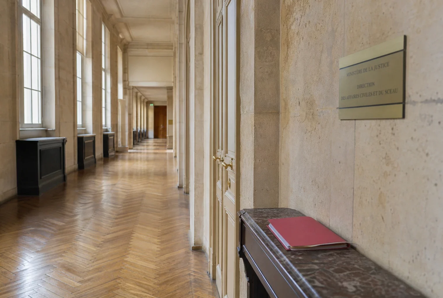 Couloir lumineux du ministère de la Justice avec dossier fermé, en référence à l’affaire Lyhanna