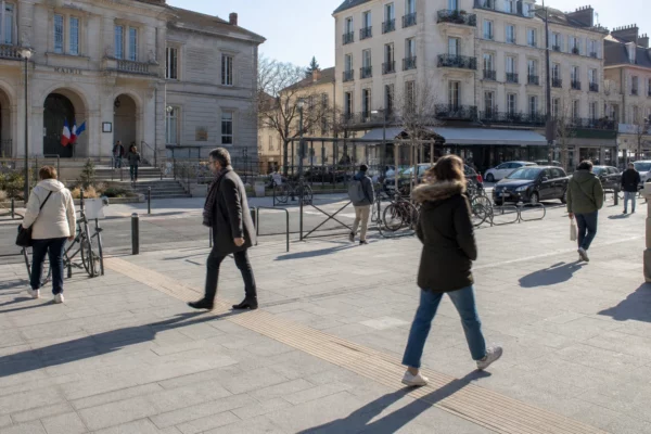 Une place de ville française près de la mairie, avec habitants anonymes et ambiance de quotidien urbain clair.