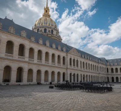 Cour des Invalides vide après un hommage national, avec la coupole en arrière-plan et une lumière claire de journée.