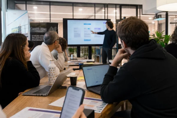 Des participants testent l’IA dans un espace de travail lumineux à Lille, en reportage photo réaliste.