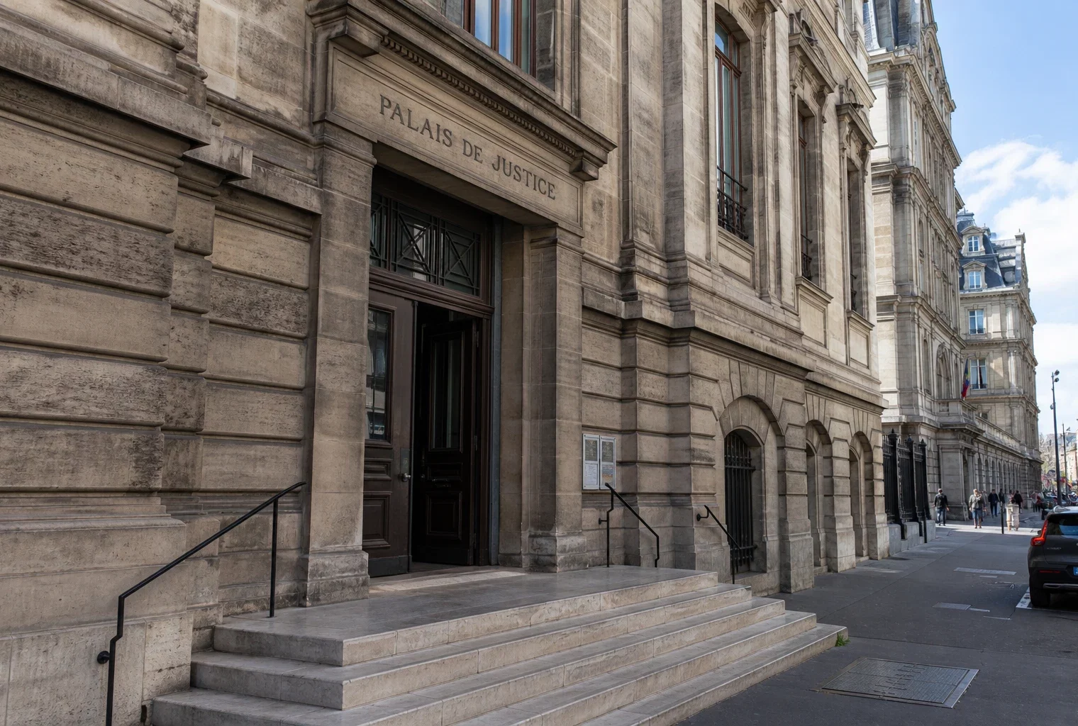Façade d’un palais de justice parisien vue en oblique, sous une lumière claire et naturelle.