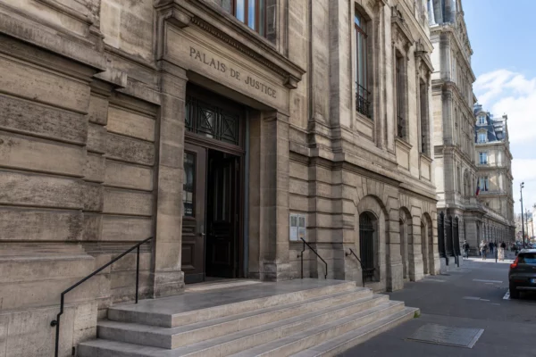 Façade d’un palais de justice parisien vue en oblique, sous une lumière claire et naturelle.