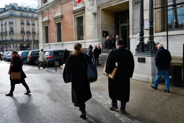 Des avocats et passants anonymes devant un palais de justice français par temps clair.