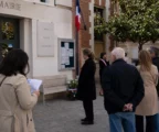 Des habitants anonymes devant une mairie parisienne lors d’un rassemblement civique en lien avec un mémorial.