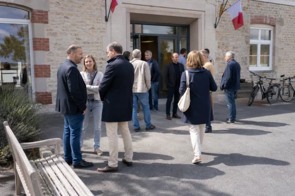 Des citoyens arrivent devant une mairie de quartier lors d’une permanence locale, dans une lumière de journée claire.