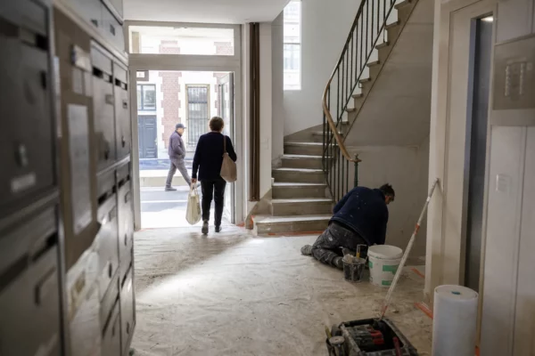 Cage d’escalier d’un immeuble résidentiel avec petits travaux de rénovation et habitants anonymes